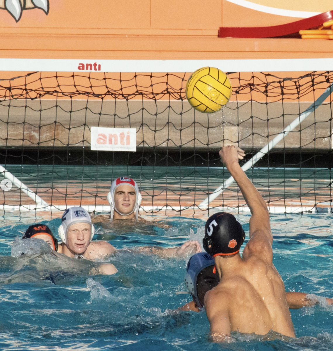 Woodside boys water polo player throws the ball into the goal during the Carlmont game.